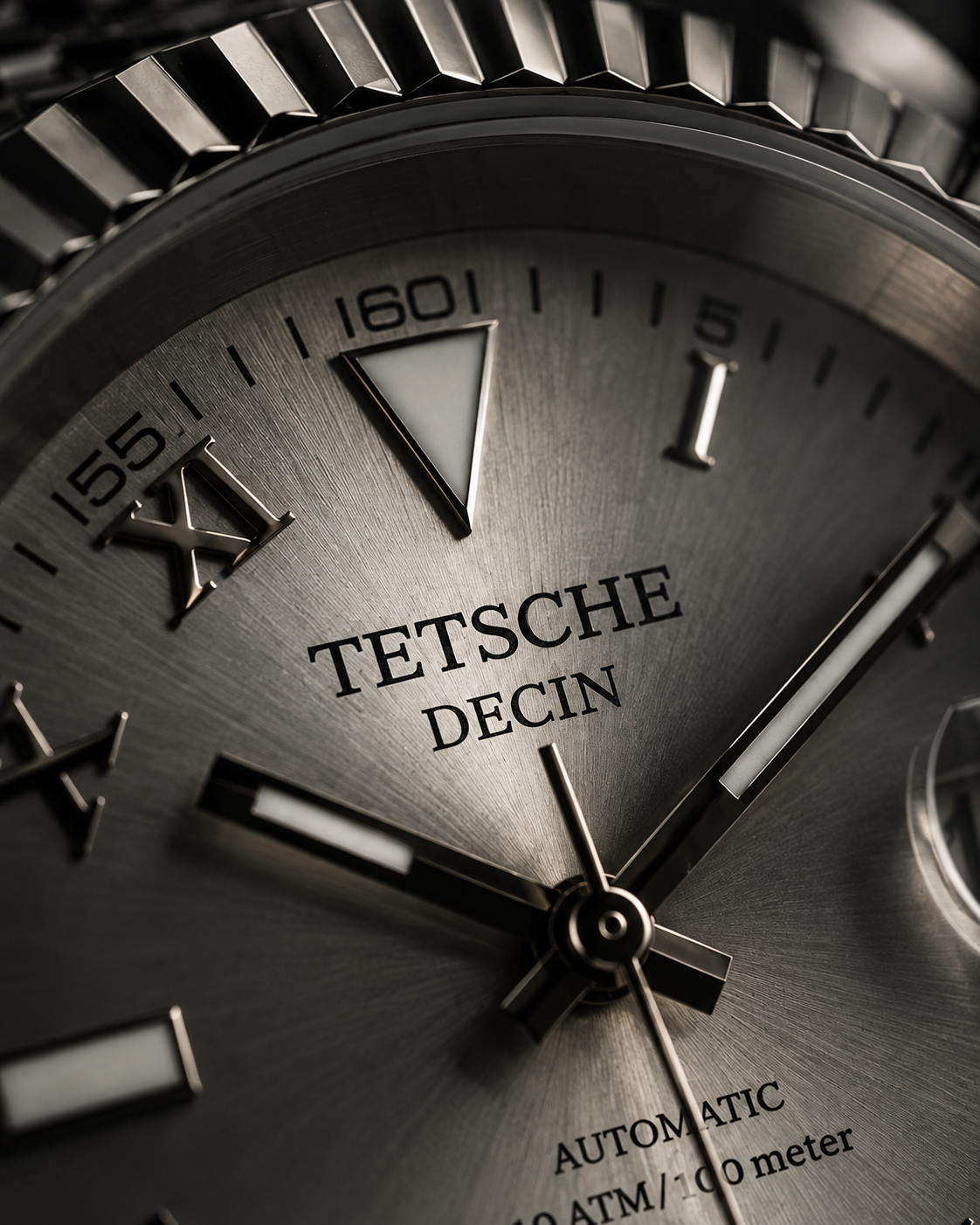 Close-up of a Tetsche Decin automatic watch dial with a brushed gunmetal gray finish, black hands, and a ridged bezel. - Tetsche Watches