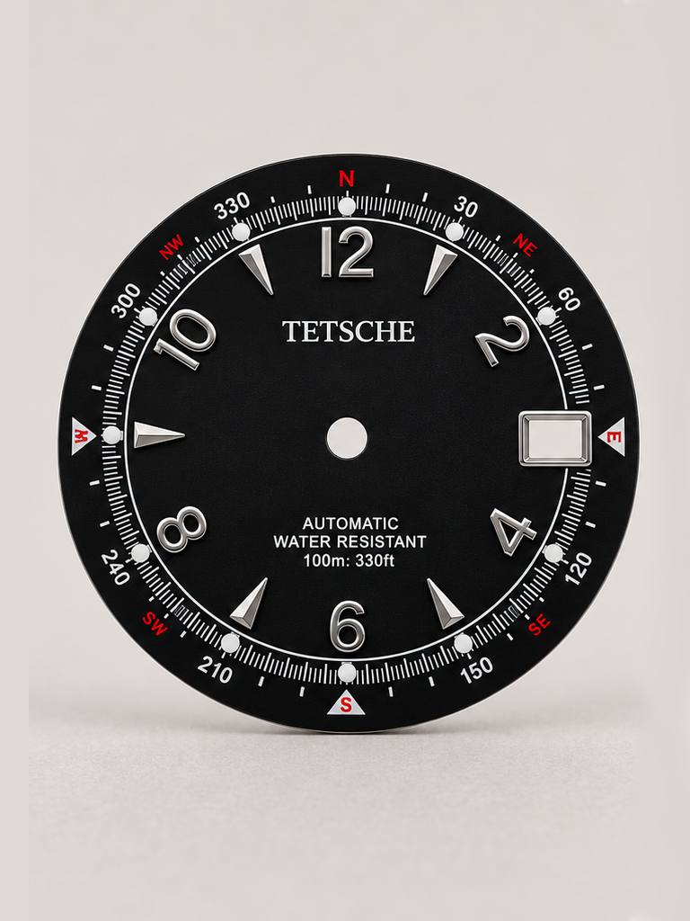 An adventure-inspired dial with a bold, instrument-style design. The combination of applied numerals, directional markings and a detailed outer scale gives the dial the character of a classic navigation instrument, while the contrasting red accents add a distinctive touch.

A perfect choice for a rugged, explorer-inspired watch build with plenty of personality.

Black
* 28.5 mm diameter
* Applied Arabic numeral hour markers
* Detailed compass-inspired outer scale
* Date window at 3 o’clock
* Contrast