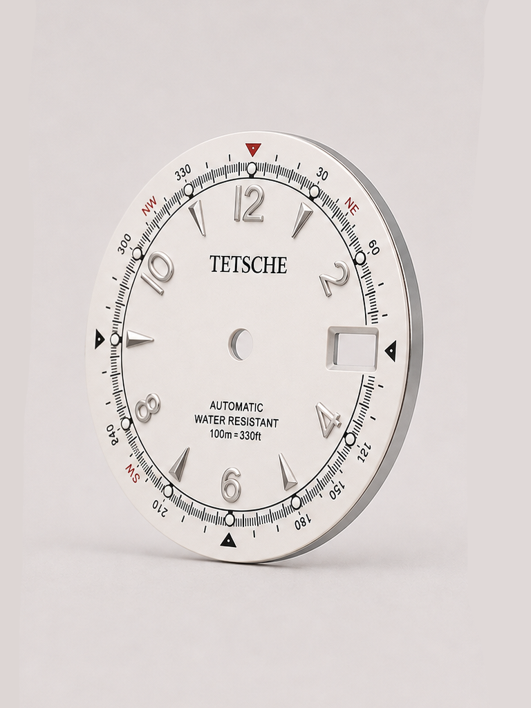 An adventure-inspired dial with a bold, instrument-style design. The combination of applied numerals, directional markings and a detailed outer scale gives the dial the character of a classic navigation instrument, while the contrasting red accents add a distinctive touch.

A perfect choice for a rugged, explorer-inspired watch build with plenty of personality.

White
* 28.5 mm diameter
* Applied Arabic numeral hour markers
* Detailed compass-inspired outer scale
* Date window at 3 o’clock
* Contrast