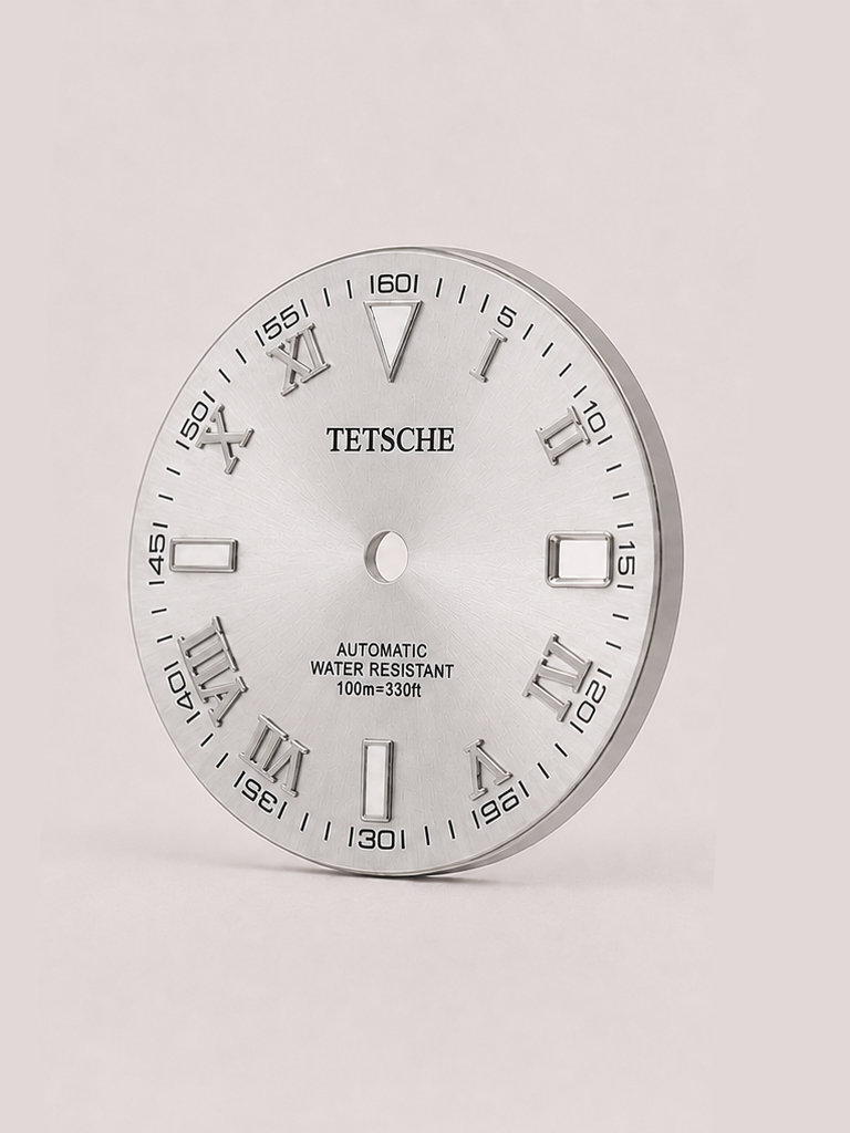 A distinctive dial that combines classical Roman numerals with a more technical, contemporary layout. The outer minute markings add depth and character, while the applied silver-tone details stand out against the dark dial for a bold yet refined appearance.

A great choice for a classic watch build that blends traditional design with a modern edge.

Silver
28.5 mm diameter
Applied Roman numeral hour markers
Detailed outer minute track
Date window at 3 o’clock
Silver-tone details
Designed for automatic wat