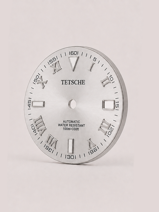 A distinctive dial that combines classical Roman numerals with a more technical, contemporary layout. The outer minute markings add depth and character, while the applied silver-tone details stand out against the dark dial for a bold yet refined appearance.

A great choice for a classic watch build that blends traditional design with a modern edge.

Silver
28.5 mm diameter
Applied Roman numeral hour markers
Detailed outer minute track
Date window at 3 o’clock
Silver-tone details
Designed for automatic wat